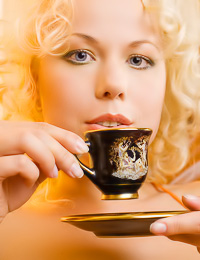 Nastiya B: Smoking hot blonde model Nastiya B drinks coffee completely nude and shows off on the sofa.